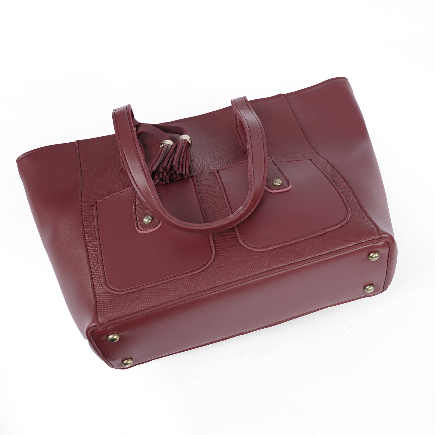 Angled view of the Alizeh maroon handbag, highlighting the stylish front flap pockets and tassel.
